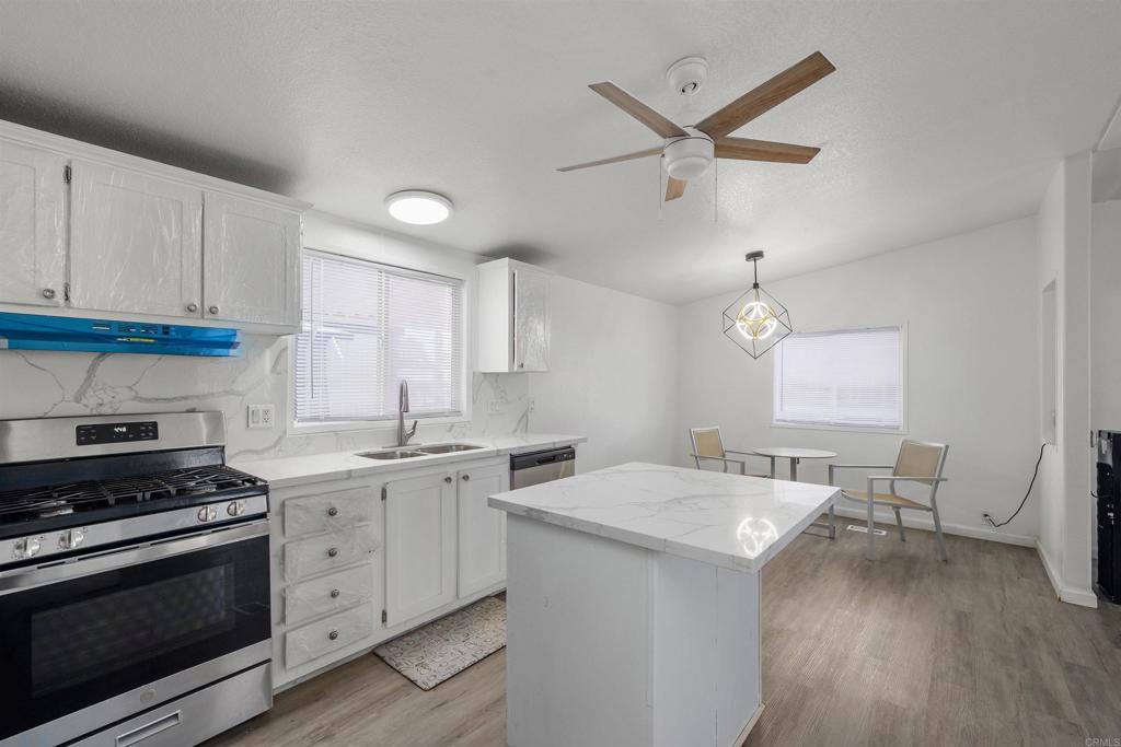 400 Greenfield Drive El Cajon, CA 92021 - Photo 16 of 41 a kitchen with a stove a sink and a refrigerator