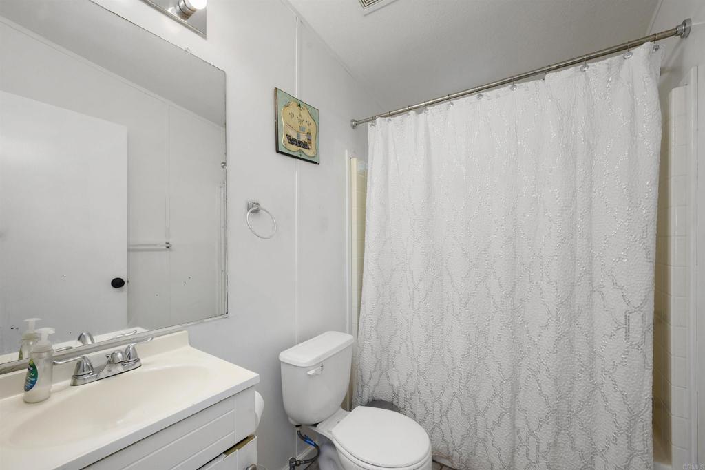 400 Greenfield Drive El Cajon, CA 92021 - Photo 25 of 41 a bathroom with a sink a toilet and shower curtain