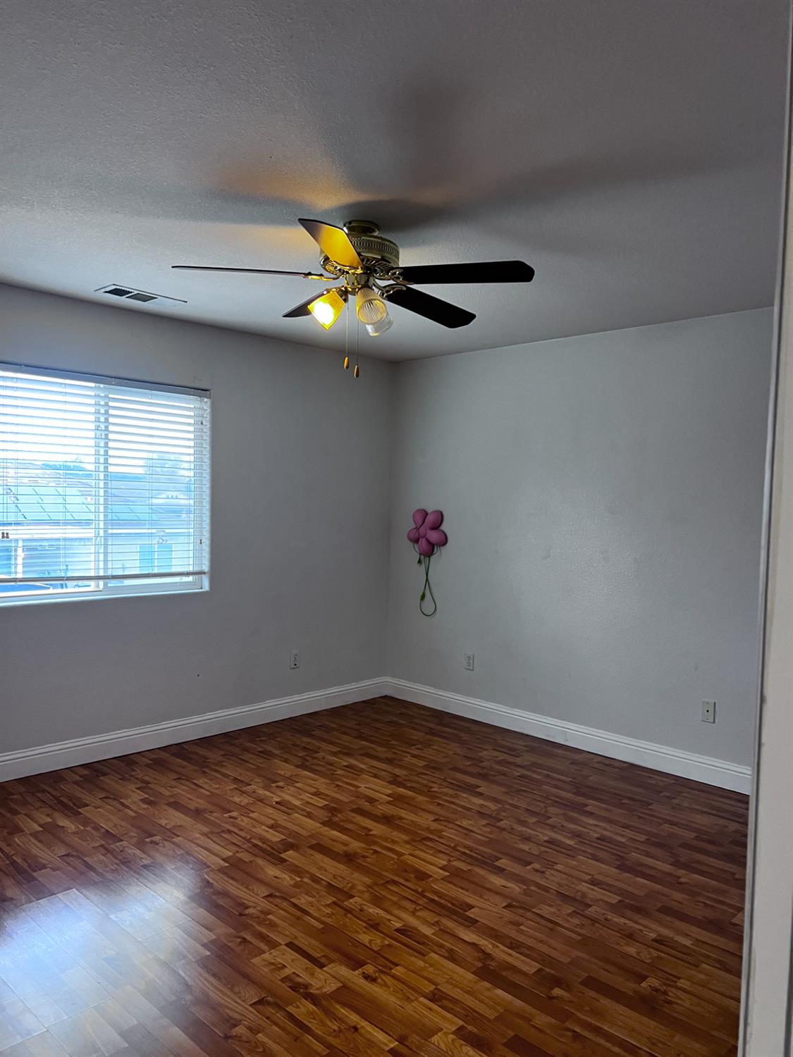 1950 West Rio Hondo Way Hanford, CA 93230 - Photo 33 of 56 a view of an empty room with a window and wooden floor