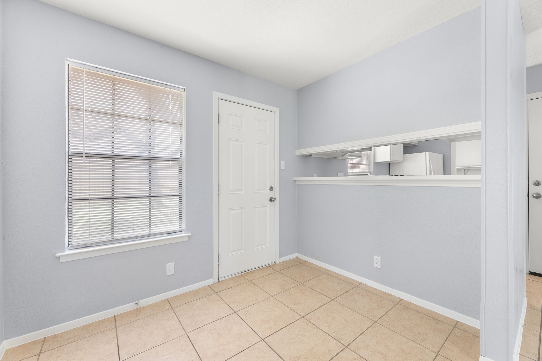 3802 Foust Trail, Unit A Georgetown, TX 78628 - Photo 8 of 34 A well-lit area featuring durable tiled flooring and a convenient pass-through to the kitchen.