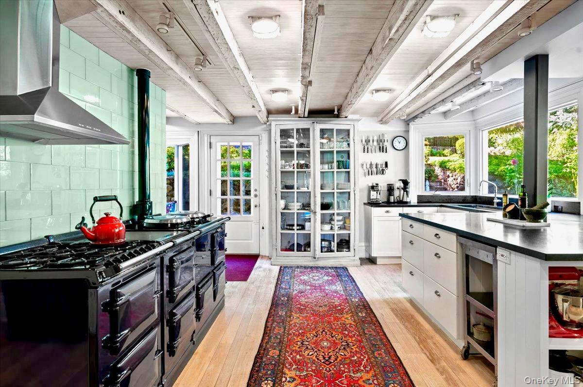 245 River Road Nyack, NY 10960 - Photo 19 of 45 Kitchen featuring wall chimney range hood, beamed ceiling, white cabinetry, light wood-type flooring, and Aga range with two ovens