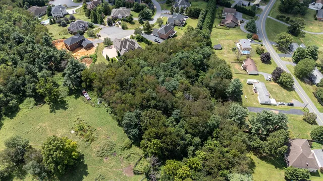 an aerial view of residential house with outdoor space and trees all around