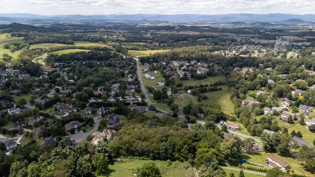 an aerial view of residential houses with outdoor space and trees