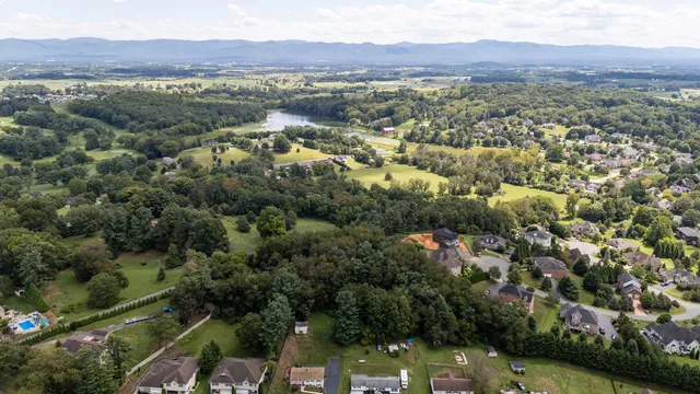 an aerial view of house with yard and mountain view in back