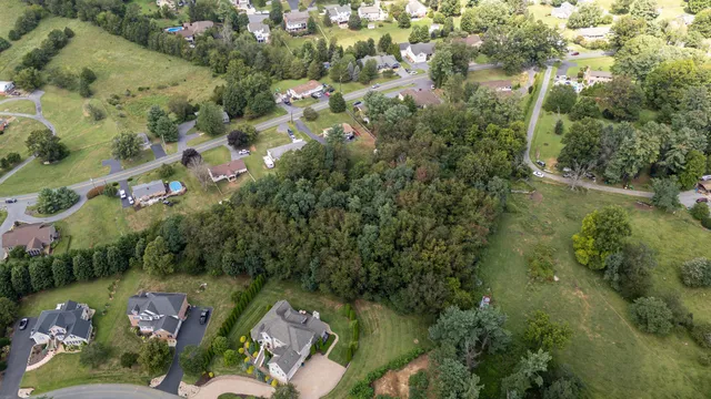 an aerial view of lake residential house with outdoor space and trees all around