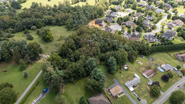an aerial view of residential houses with outdoor space and trees