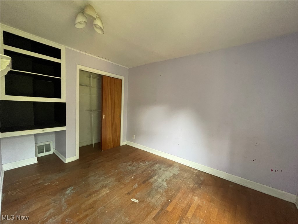 35 Arbor Road Northeast Minerva, OH 44657 - Photo 10 of 15 Unfurnished bedroom featuring hardwood / wood-style flooring, built in desk, and a closet