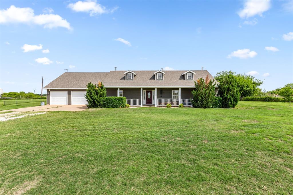 13315 Highway 281 Scotland, TX 76379 - Photo 1 of 40 Ranch-style home featuring gray exterior with white trim, a covered front porch with white railings, and a two-car attached garage