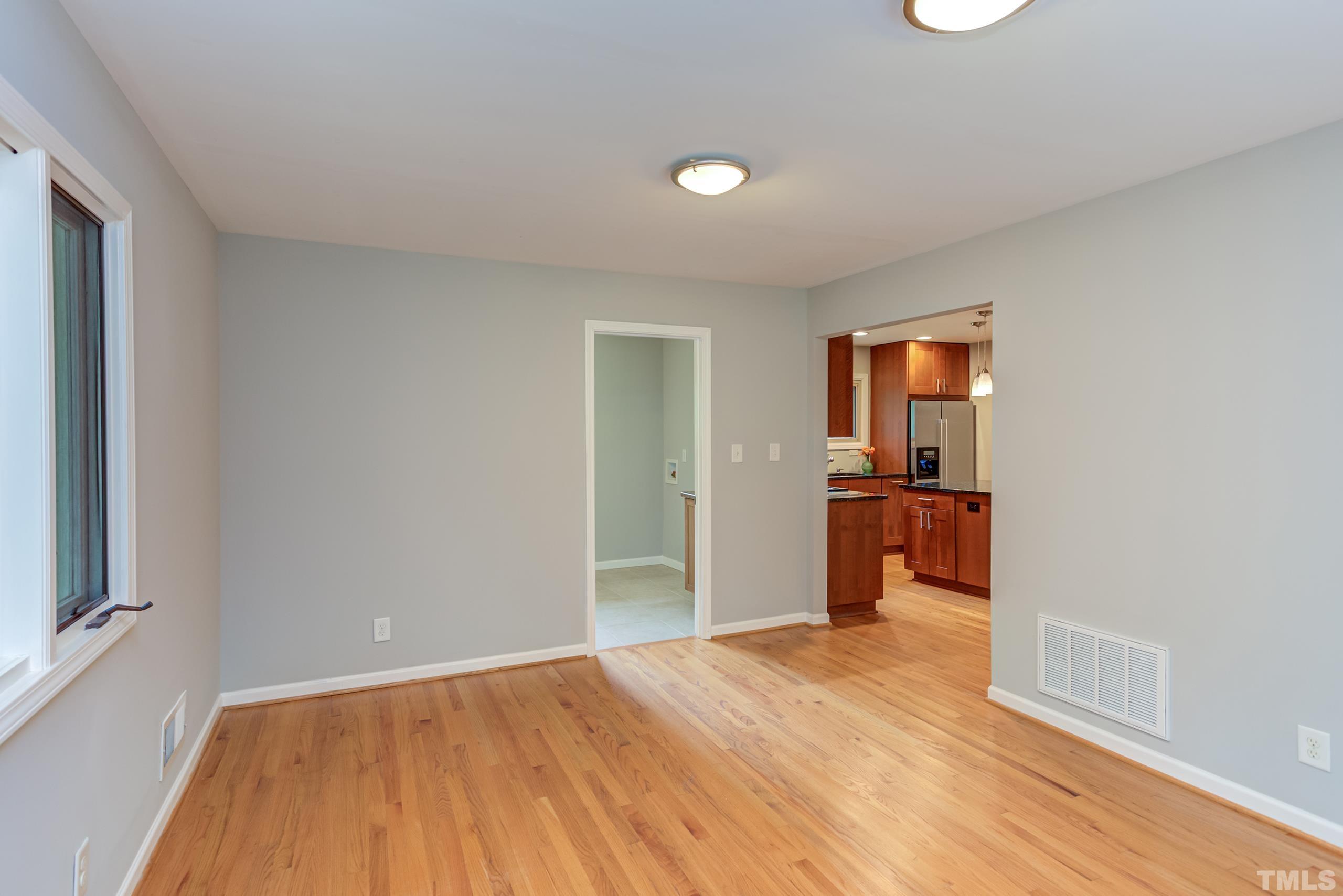 912 Winona Road Raleigh, NC 27609 - Photo 14 of 30 a view of a livingroom with wooden floor and a kitchen