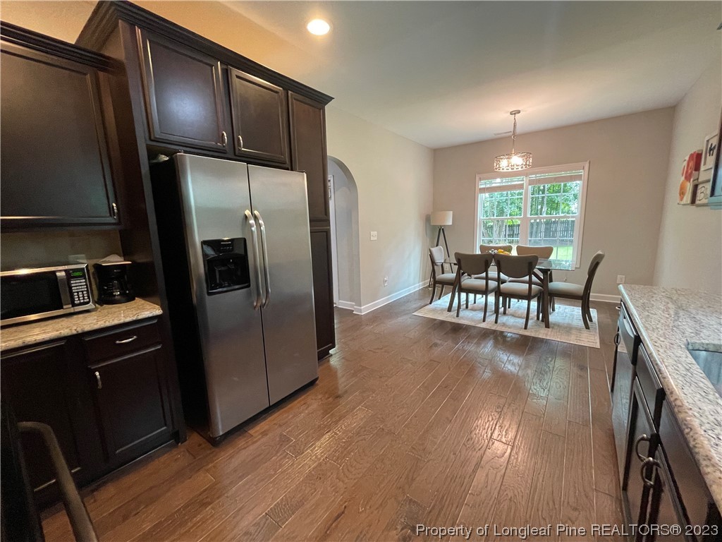 6298 Phillipi Church Road Raeford, NC 28376 - Photo 17 of 31 a kitchen with stainless steel appliances granite countertop a refrigerator a stove a sink a dining table and chairs with wooden floor