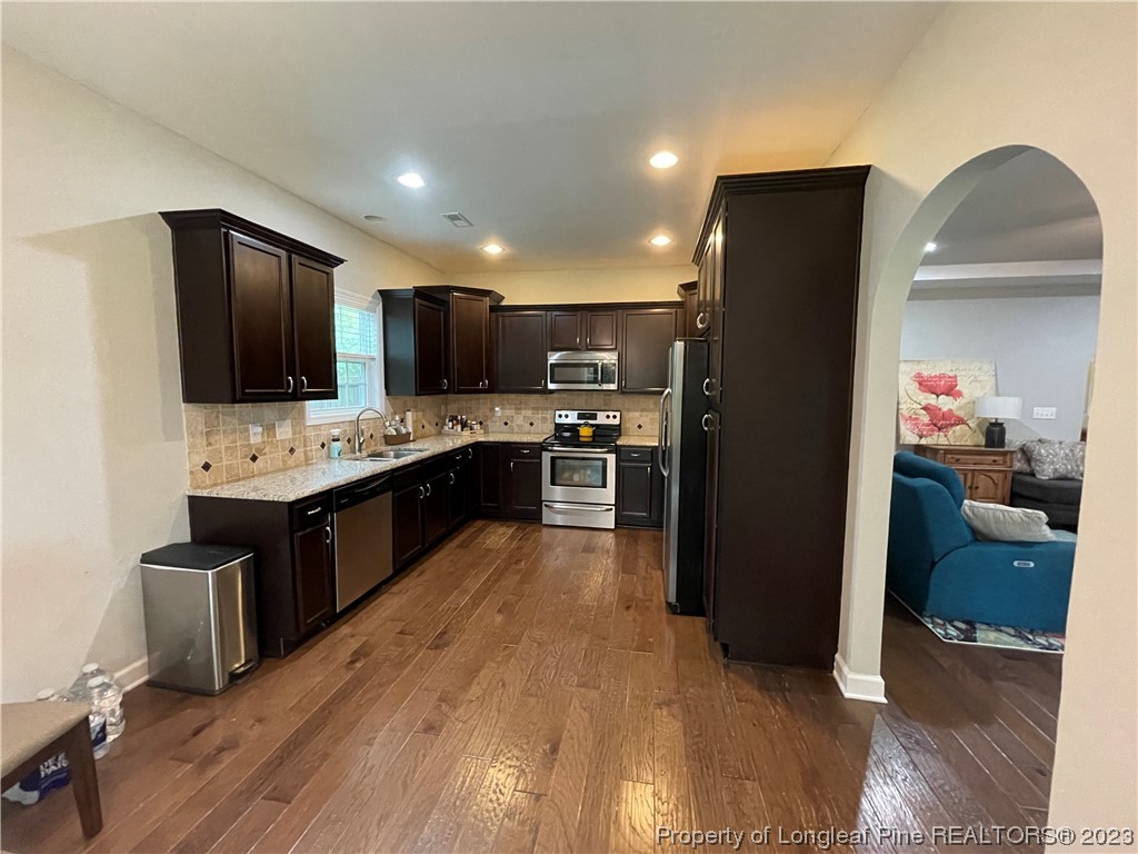 6298 Phillipi Church Road Raeford, NC 28376 - Photo 18 of 31 a large kitchen with stainless steel appliances kitchen island granite countertop a stove refrigerator and a sink