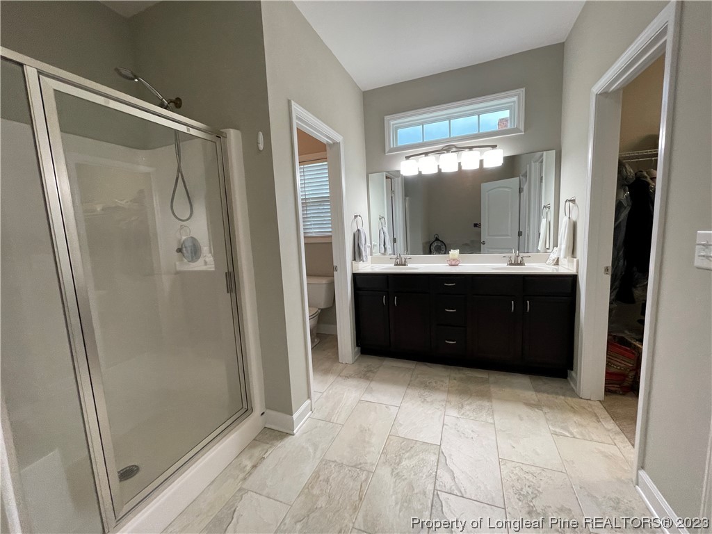 6298 Phillipi Church Road Raeford, NC 28376 - Photo 21 of 31 a bathroom with a double vanity sink mirror and shower
