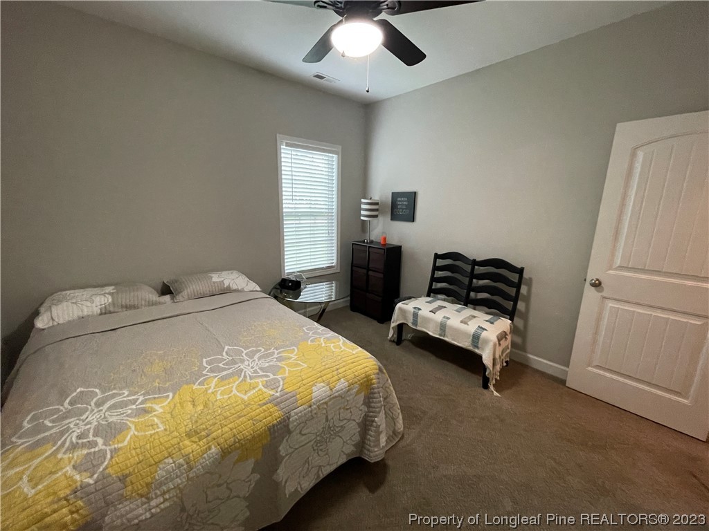 6298 Phillipi Church Road Raeford, NC 28376 - Photo 9 of 31 a spacious bedroom with a bed and a chandelier