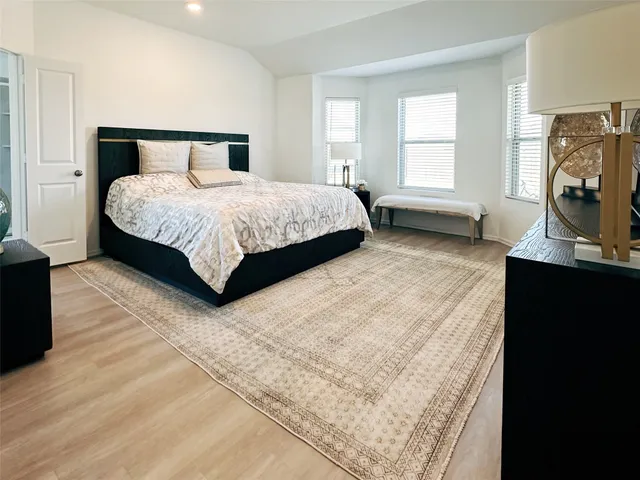 a bedroom with a bed flat screen tv and window
