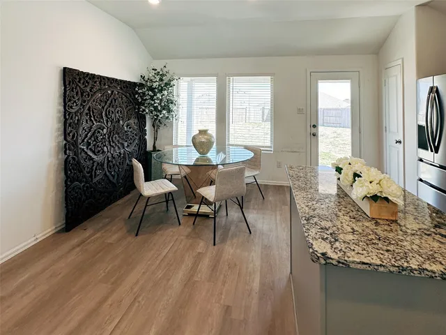 a dining room with furniture and wooden floor