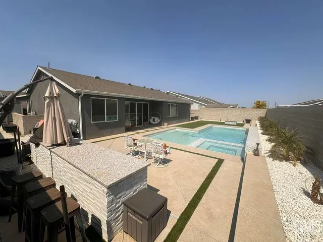 a view of a patio with table and chairs a barbeque with wooden floor and a yard