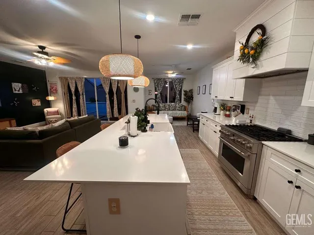 a kitchen with stainless steel appliances a table chairs and a wooden floor