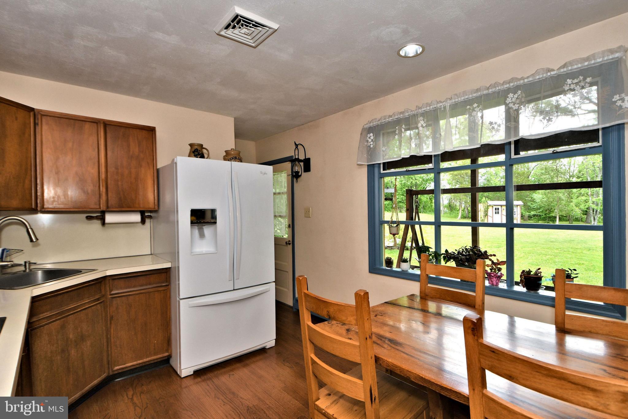 24 Moyer Road Telford, PA 18969 - Photo 13 of 62 a kitchen with a refrigerator a stove and a dining table with wooden floor