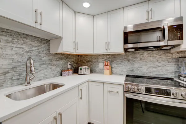 a kitchen with stainless steel appliances granite countertop a sink a stove a microwave and cabinets
