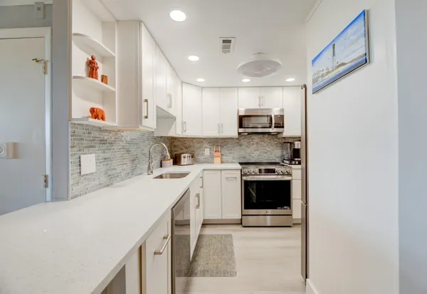 a kitchen with stainless steel appliances a stove a sink and a refrigerator