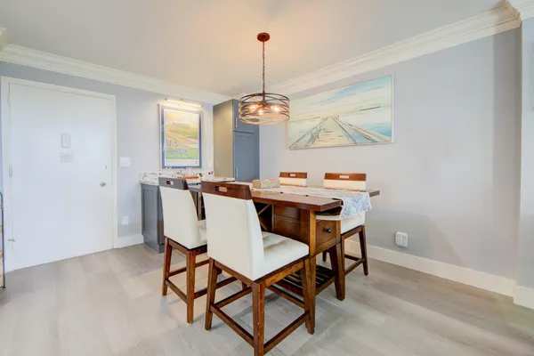 a dining room with furniture a chandelier and wooden floor