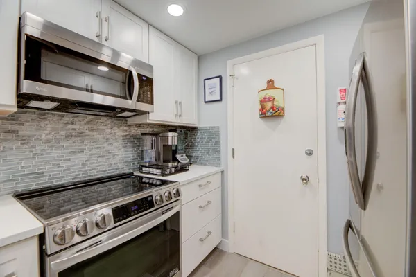 a kitchen with stainless steel appliances a stove microwave and a refrigerator