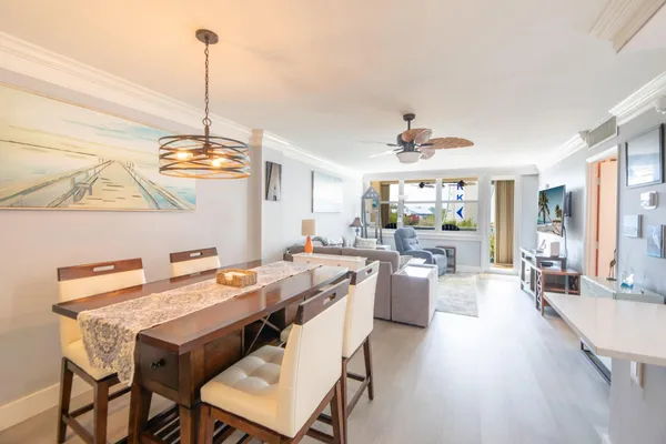 a view of a dining room and livingroom with furniture wooden floor a chandelier