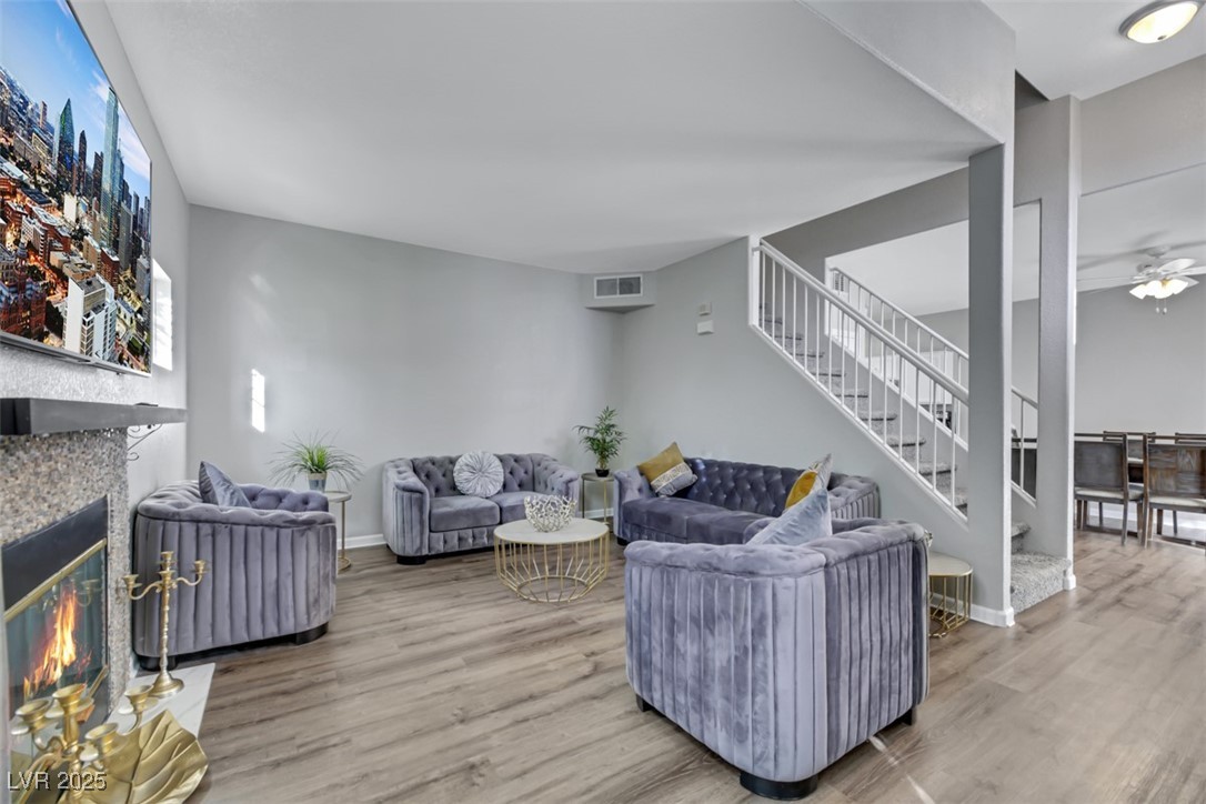 2907 Rio Sonora Court Henderson, NV 89074 - Photo 6 of 35 Living area featuring wood finished floors, stairway, a tile fireplace, and a ceiling fan