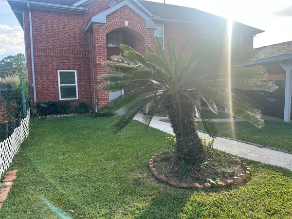 a vase of flowers sitting in front of a brick house