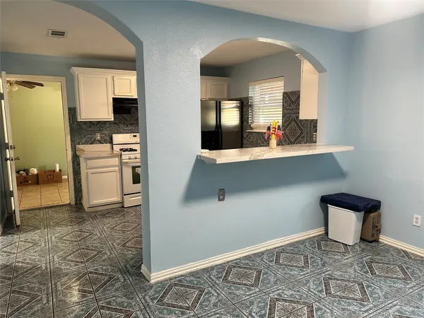 a view of a hallway with kitchen and dining room