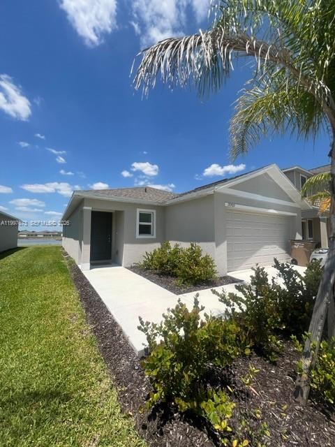 19709 Garden Ridge, Unit 19709 Lehigh Acres, FL 33974 - Photo 2 of 11 a front view of a house with garden