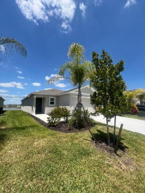 19709 Garden Ridge, Unit 19709 Lehigh Acres, FL 33974 - Photo 3 of 11 a front view of a house with garden