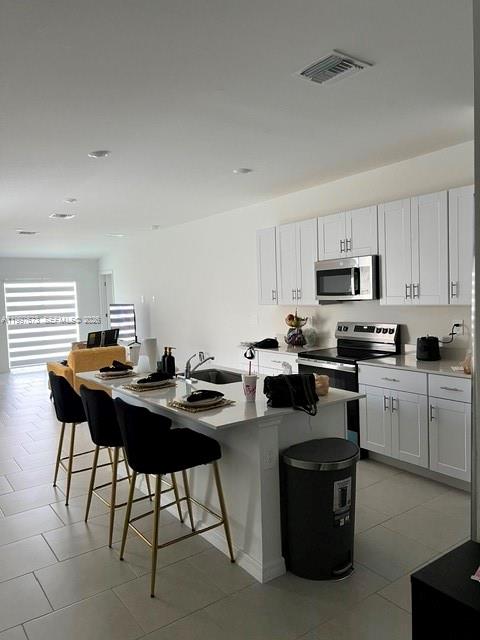 19709 Garden Ridge, Unit 19709 Lehigh Acres, FL 33974 - Photo 4 of 11 a kitchen with cabinets a sink and appliances
