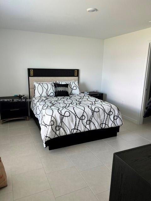 19709 Garden Ridge, Unit 19709 Lehigh Acres, FL 33974 - Photo 7 of 11 a bedroom with a bed chair and a lamp on table