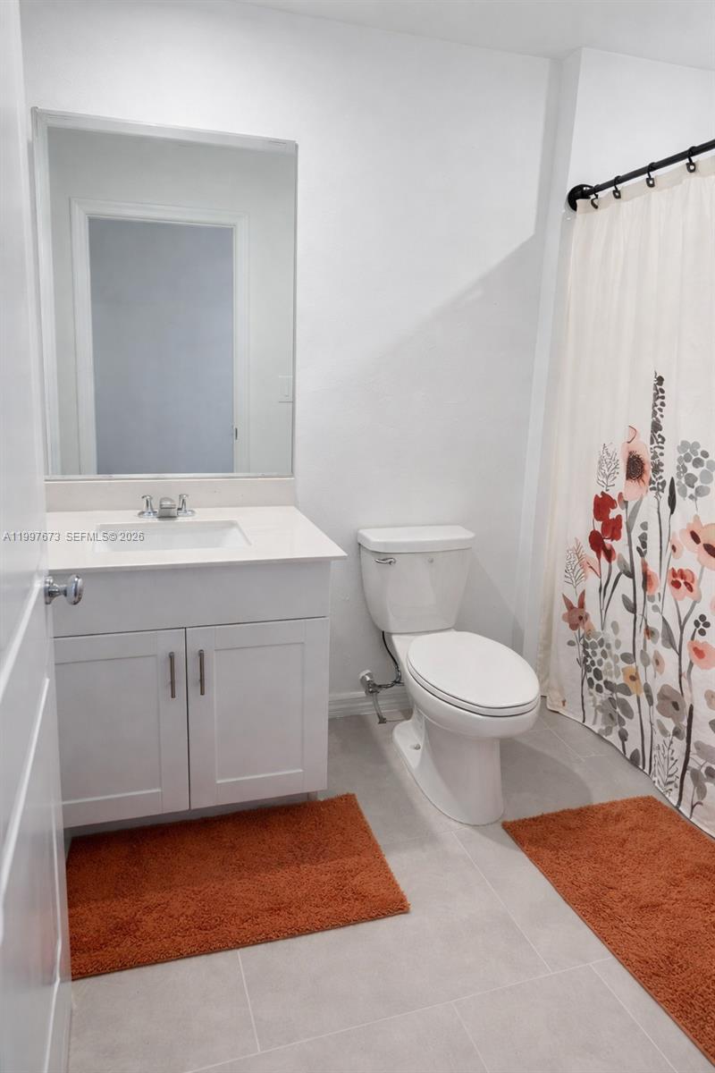 19709 Garden Ridge, Unit 19709 Lehigh Acres, FL 33974 - Photo 10 of 11 a bathroom with a sink a toilet and a mirror