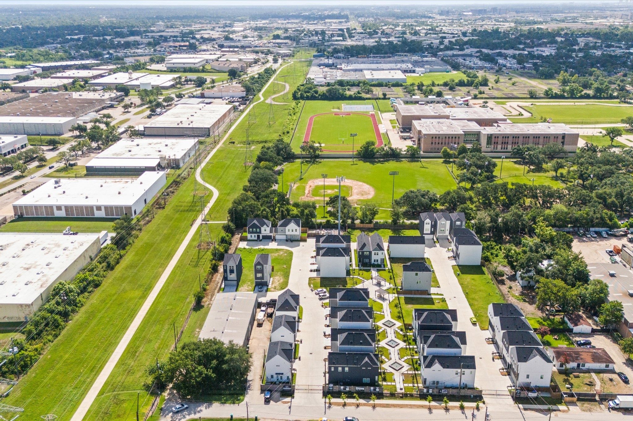 8319 Springwood Drive Houston, TX 77055 - Photo 39 of 47 From above, Springwood Villas reveals its harmonious blend of architecture, greenery, and shared spaces. Homes are arranged in elegant rows, connected by winding pathways that lead to a central community courtyard—a lush oasis featuring pergolas, shaded seating, and water fountains.