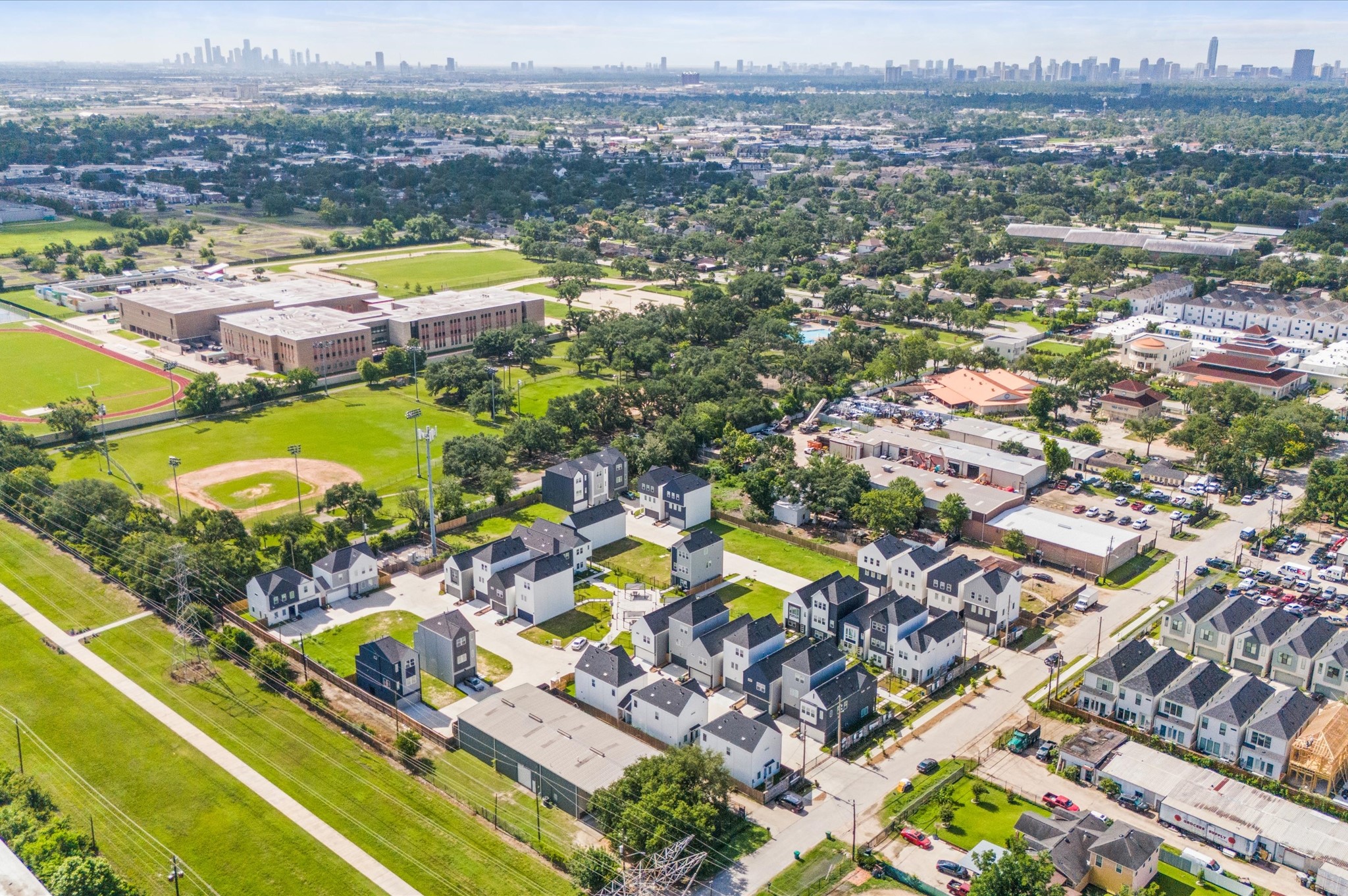 8319 Springwood Drive Houston, TX 77055 - Photo 40 of 47 From above, Springwood Villas reveals its harmonious blend of architecture, greenery, and shared spaces. Homes are arranged in elegant rows, connected by winding pathways that lead to a central community courtyard—a lush oasis featuring pergolas, shaded seating, and water fountains.
