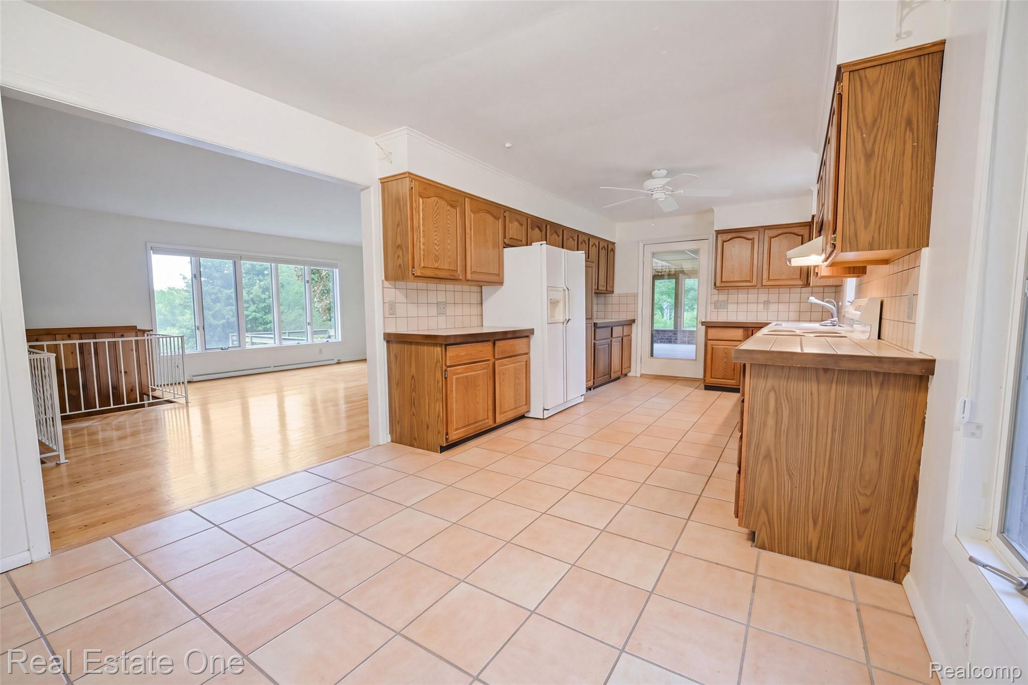 895 Rowe Road Milford, MI 48380 - Photo 31 of 50 Kitchen featuring extensive wood cabinetry, tile flooring, and a tile backsplash.