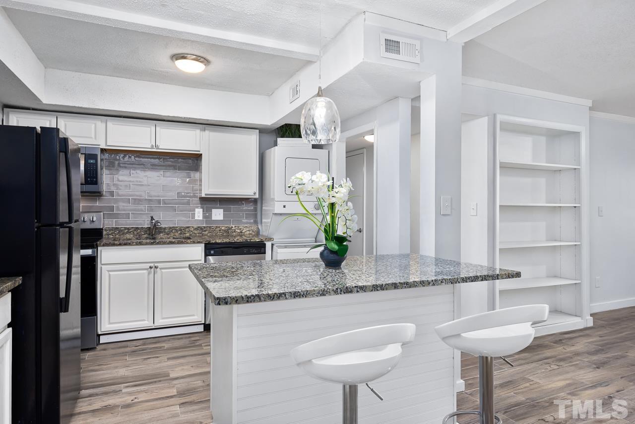 a kitchen with stainless steel appliances granite countertop a sink and a refrigerator