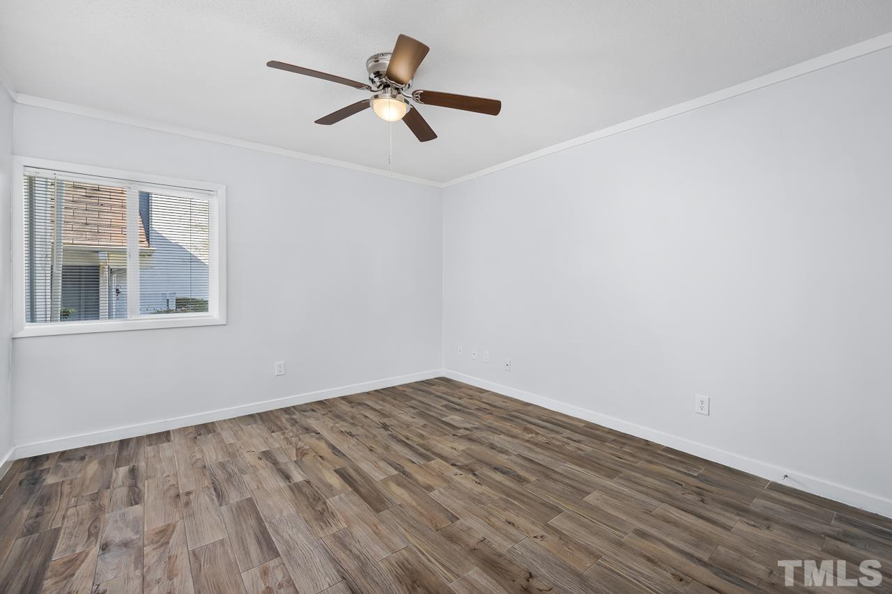 7002 Longstreet Drive, Unit C Raleigh, NC 27615 - Photo 11 of 18 a view of empty room with wooden floor and fan