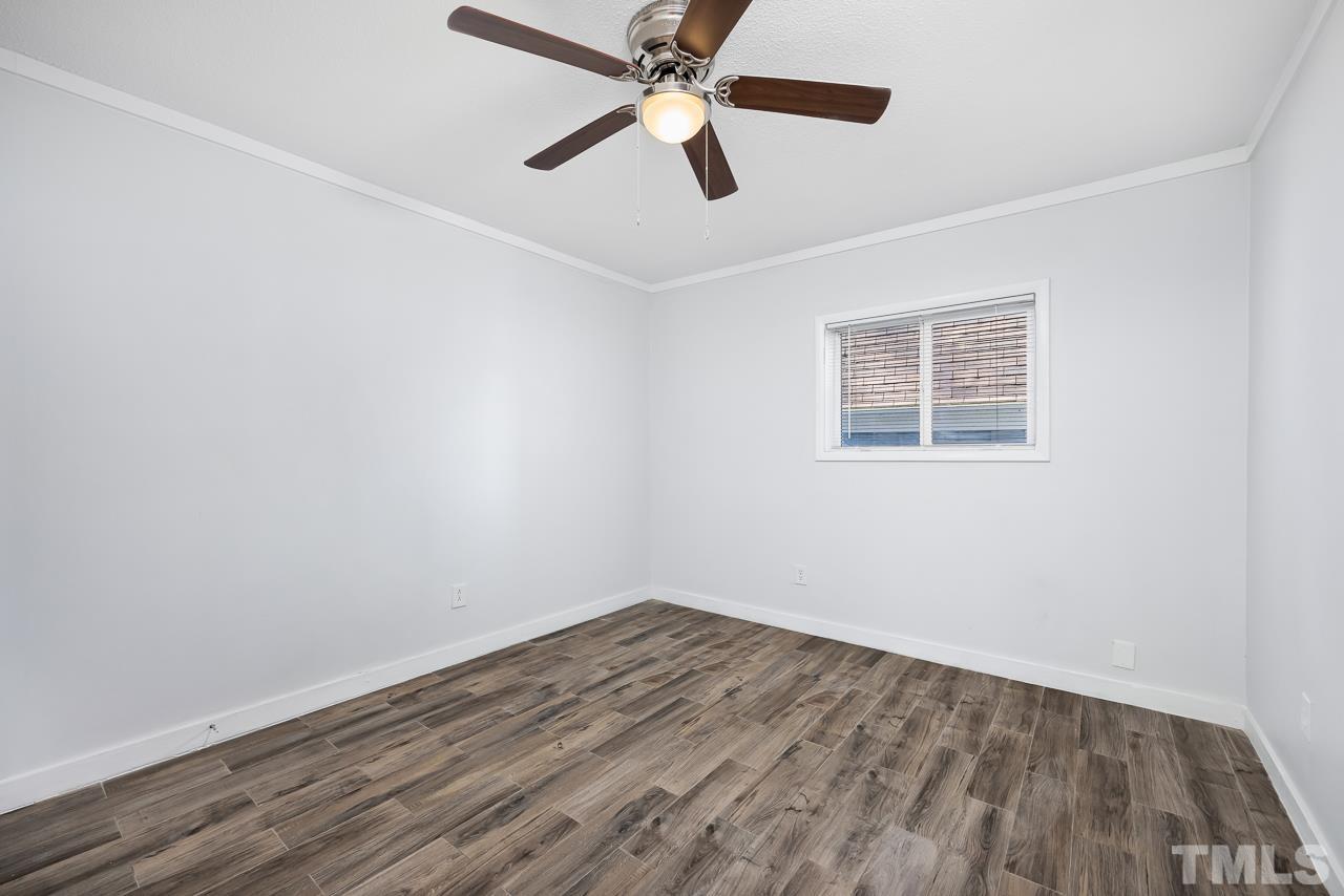 7002 Longstreet Drive, Unit C Raleigh, NC 27615 - Photo 12 of 18 an empty room with a window and a ceiling fan