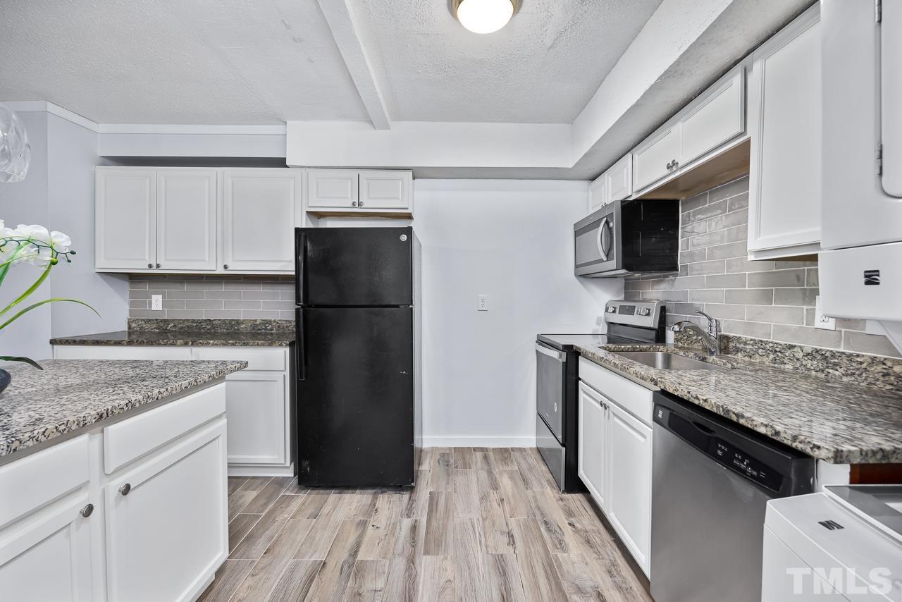 7002 Longstreet Drive, Unit C Raleigh, NC 27615 - Photo 8 of 18 a kitchen with a refrigerator and a sink