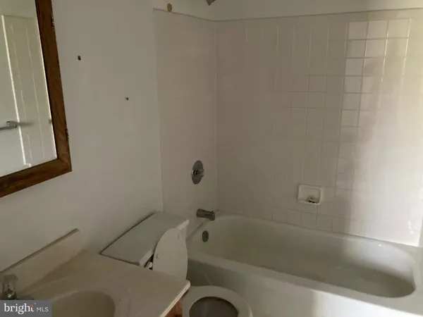 a bath tub sitting next to a white toilet and a sink