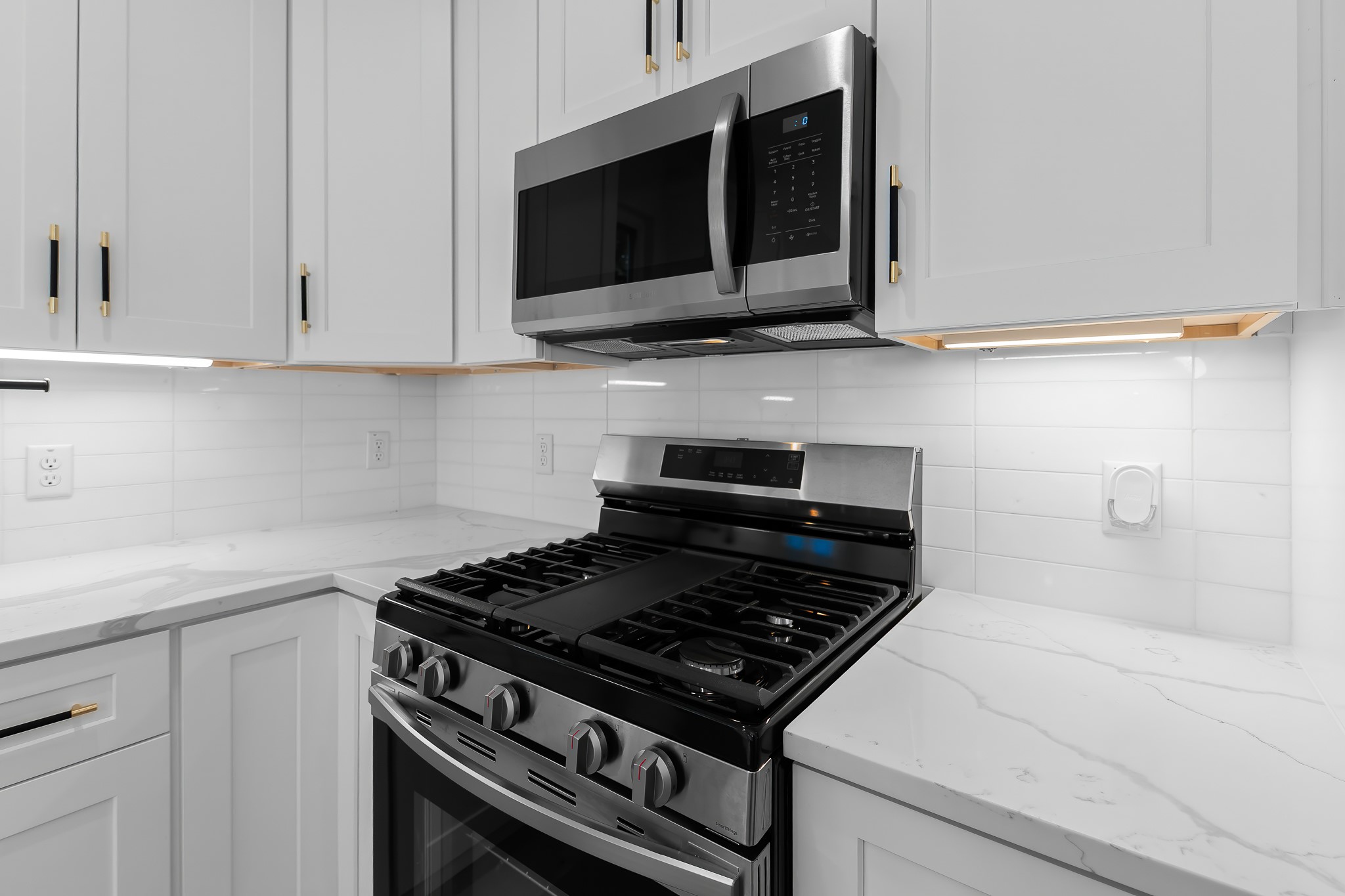 5305 Ledesma Road, Unit 4 Austin, TX 78721 - Photo 5 of 40 Culinary delights await with this kitchen's high-end gas range and built-in microwave, complemented by elegant countertops.