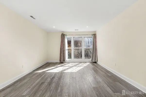 a view of an empty room with wooden floor