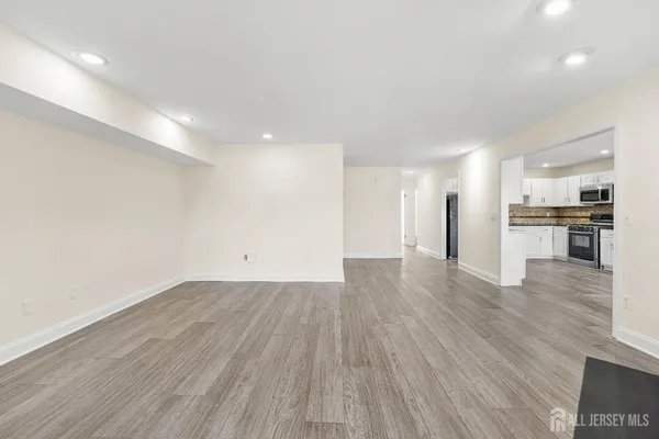 a view of a kitchen with a fridge and wooden floor