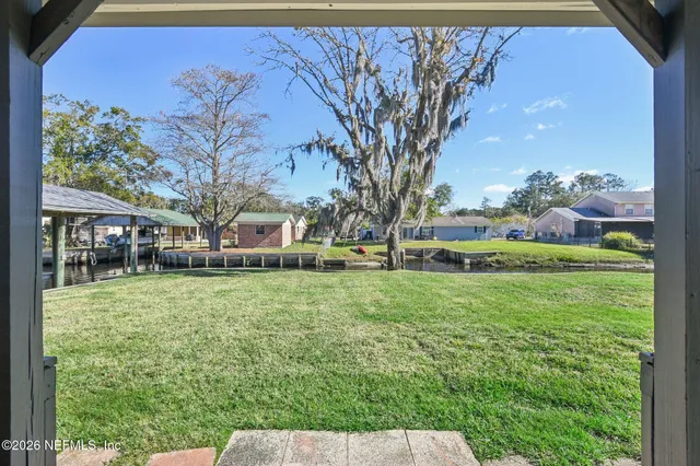 a view of empty room with wooden floor and window
