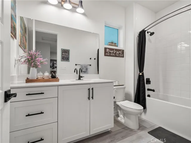 a bathroom with a sink a toilet a mirror and shower