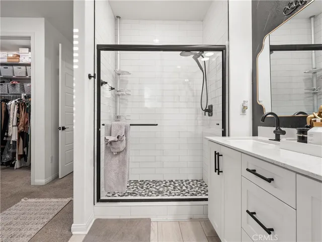 a bathroom with a shower sink and mirror