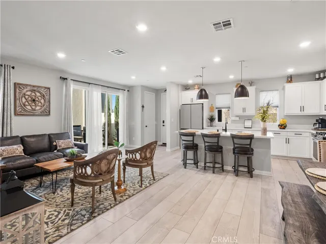 a living room with stainless steel appliances kitchen island granite countertop furniture and a large window